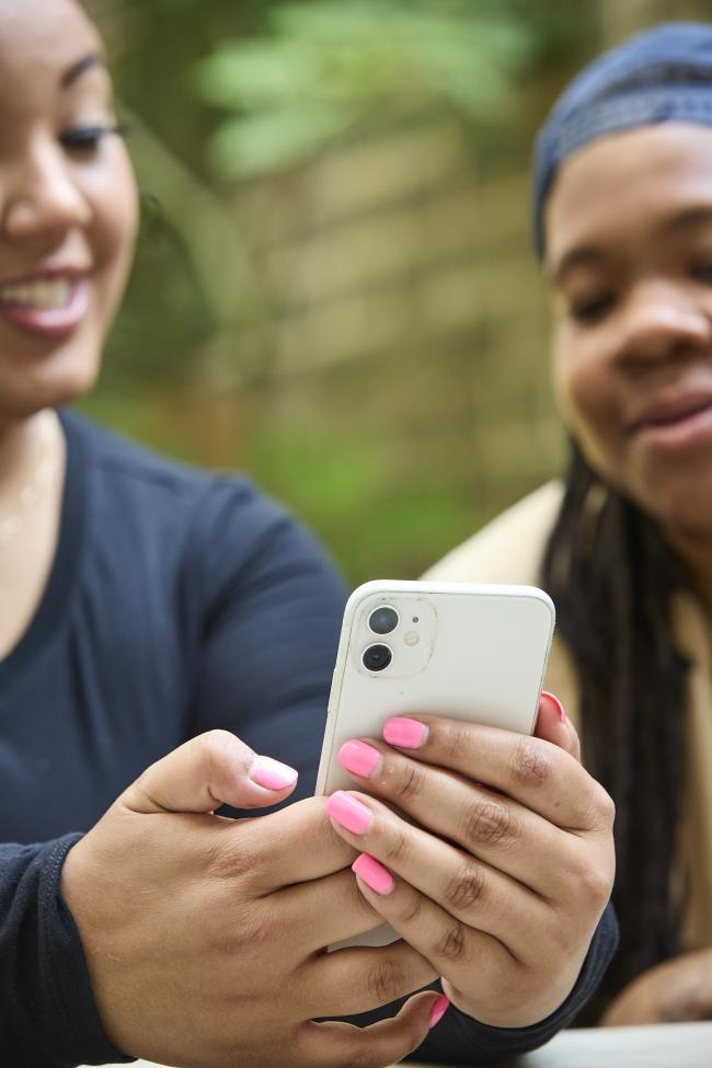 Two people looking at a phone with the Planned Parenthood Direct App